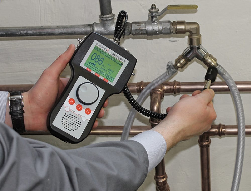 Plumber testing pipes with electronic leak detection equipment in Redlands