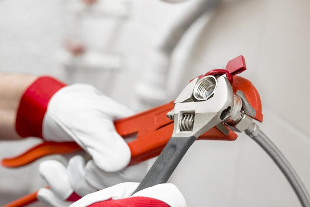 Plumber holding pipe wrenches for an emergency repair in Redlands