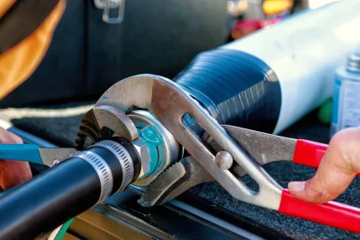Technician tightening an industrial pipe connection in Redlands