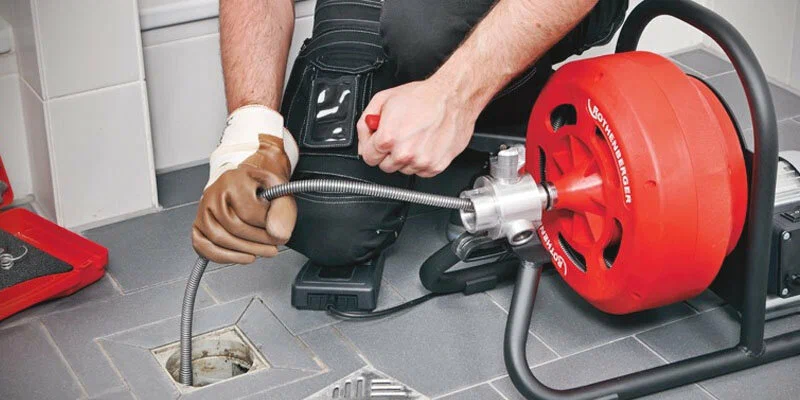 Plumber using a drain-cleaning machine in Redlands