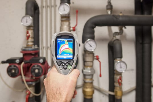 Plumber using a thermal imaging camera to inspect pipes in Redlands