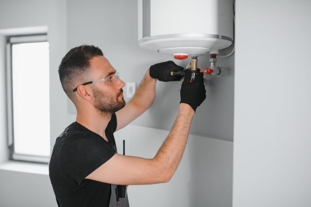Technician performing water heater maintenance in Redlands