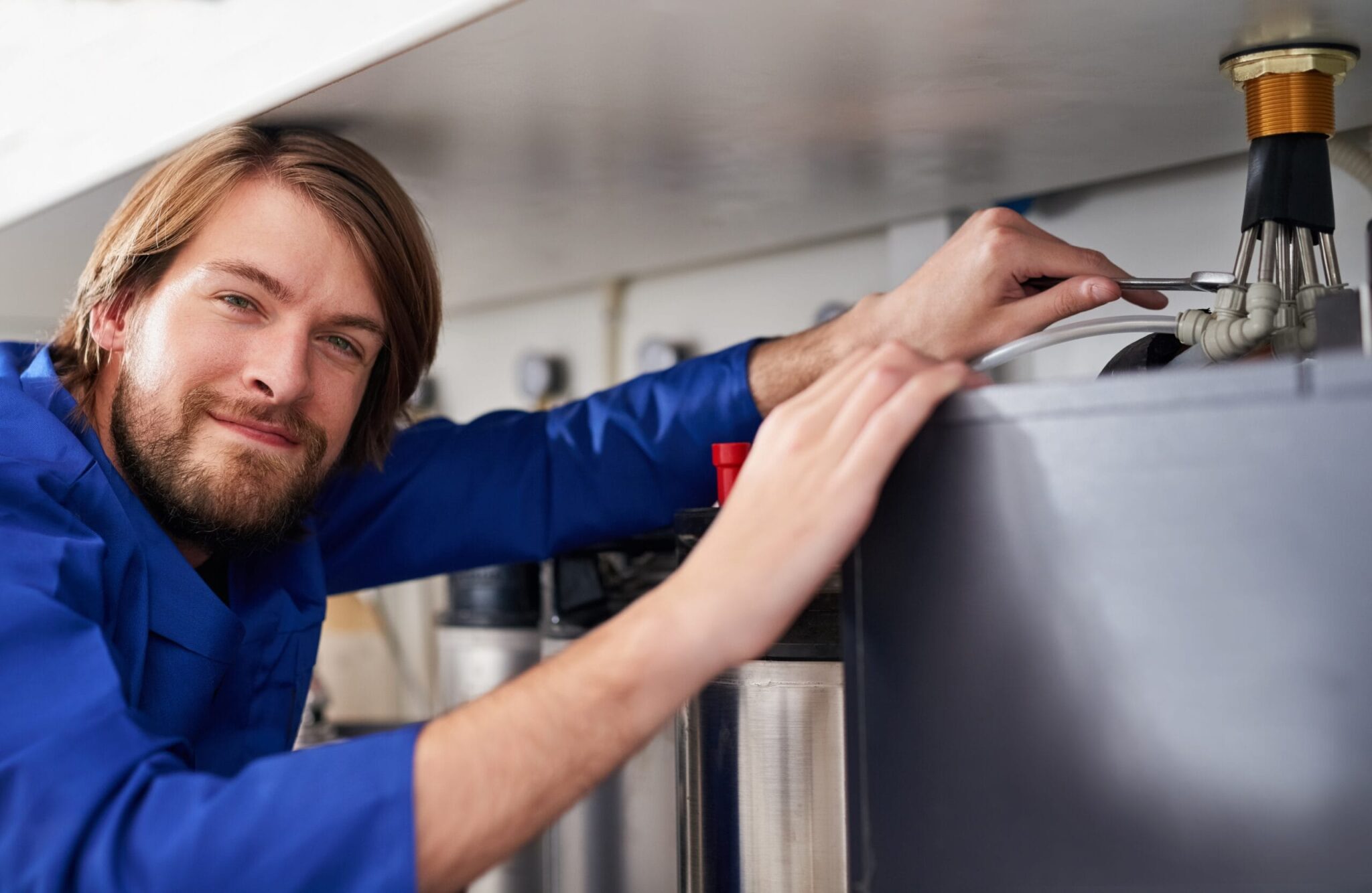Technician servicing a residential water heater tank in Redlands